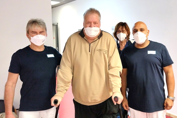 Gruppenbild eines Patienten mit Krücken und drei Personen vom Team Physiotherapie der Klinik am Park in Bad Schwalbach